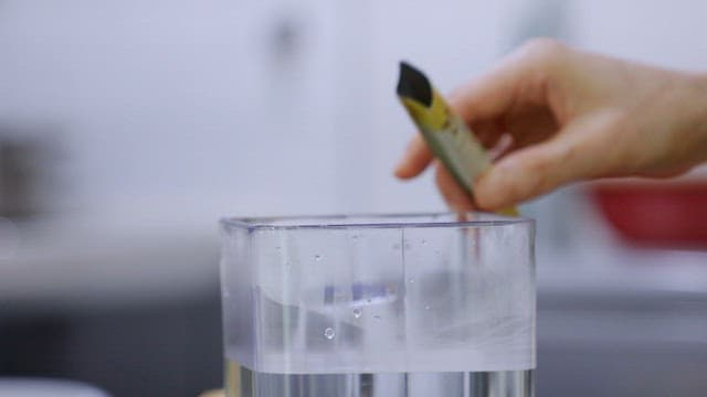 Hand with lemon juice in water