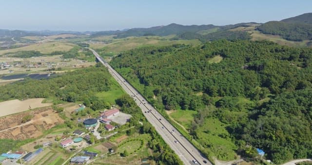 Highway cutting through lush green hills