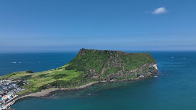 Seongsan Ilchulbong with Lush Greenery and Serene Sea on a Sunny Day