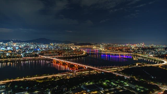 Night View Illuminated by the Lights of Buildings and Traffic in a Riverside City