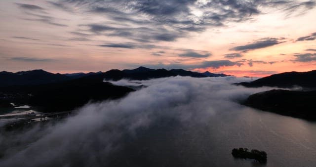 Serene river with misty mountains at dawn