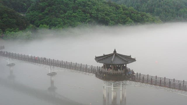 Misty Lakeside Pavilion with People Walking