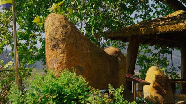 Rock tower surrounded by trees and greenery