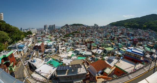 Day to night view of a densely populated residential area on a hill