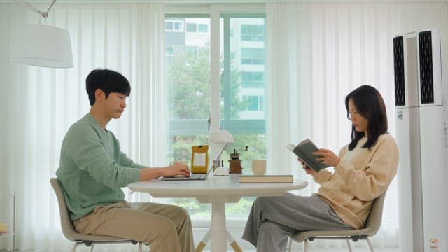 Two people relaxing in their living room at home during the day