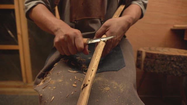 Craftsman carving wood indoors