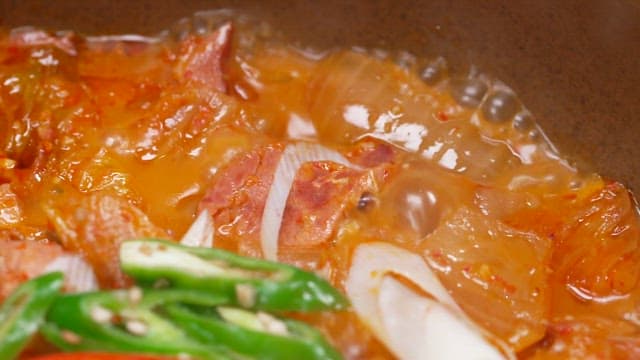 Kimchi stew with smoked duck, fresh chili peppers and green onions