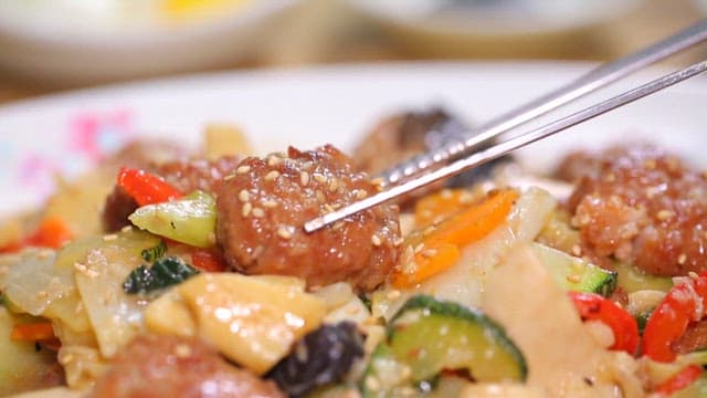 Chopstickful of delicious stir-fried meatballs and vegetables