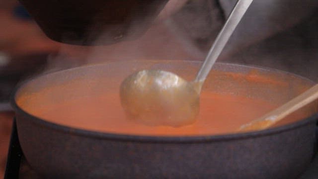 Ladle pouring porridge into a bowl