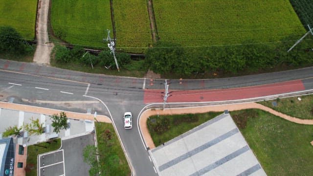 Car driving along a rural road by fields