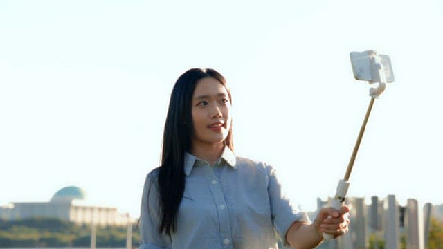 Woman taking a selfie in a park