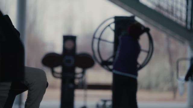 Woman exercising on outdoor gym equipment