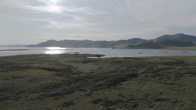 Sunshine Serene Lakeside View with Distant Mountains