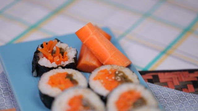 Plate of kimbap with mustard leaves and carrots