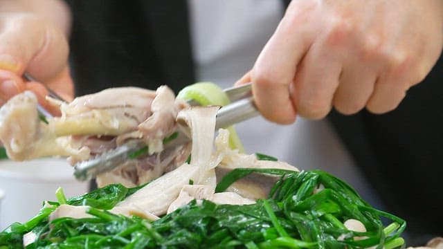 Leg of a native chicken being lifted with tongs