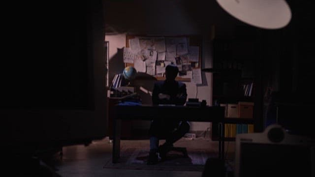 Silhouetted Man Contemplating in a Dark Office