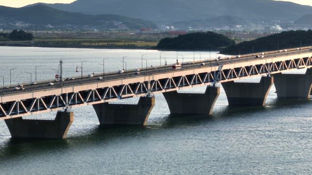 Bridge over a sea with mountains in the background