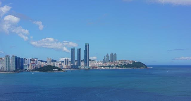 Busan, a modern city with high-rise buildings and calm, blue sea