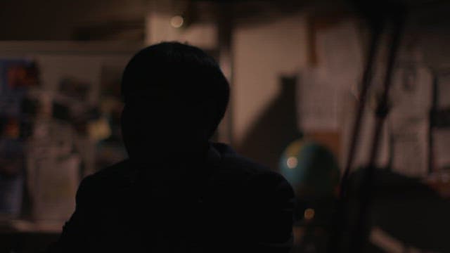 Silhouetted Man Contemplating in a Dark Office