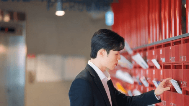 Man checking mail at red mailbox