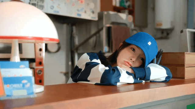 Woman in a blue hat bored at the counter