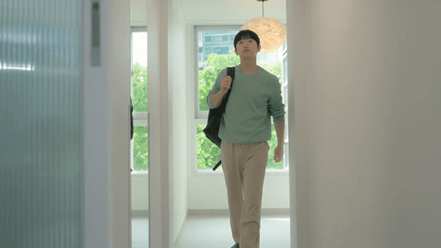 Man carrying a bag and walking through house with bright interior
