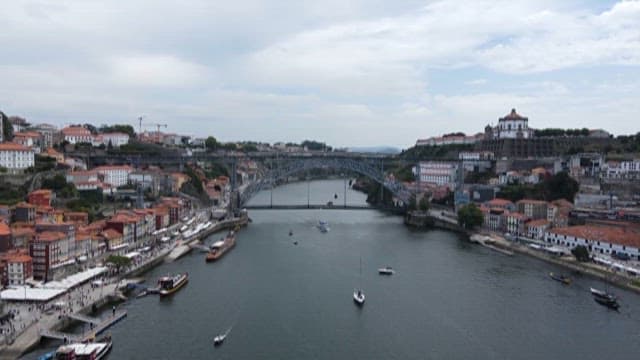 Riverside City with Boats and Historic Bridges