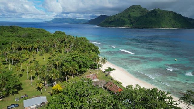 Aerial view of a beach with clear water and huts