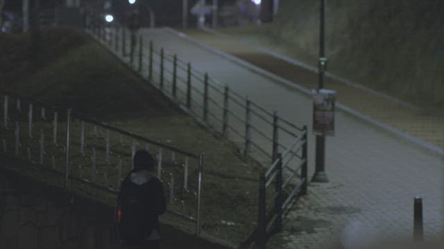 Girl walking alone on a dimly lit street at night