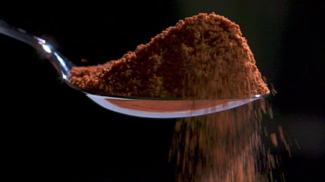 Soft chocolate powder dripping from a spoon