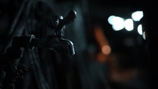 Water dripping from a tap inside a dark mine