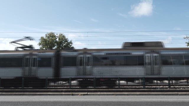 Train Passing by a Mural in a City on a Sunny Day