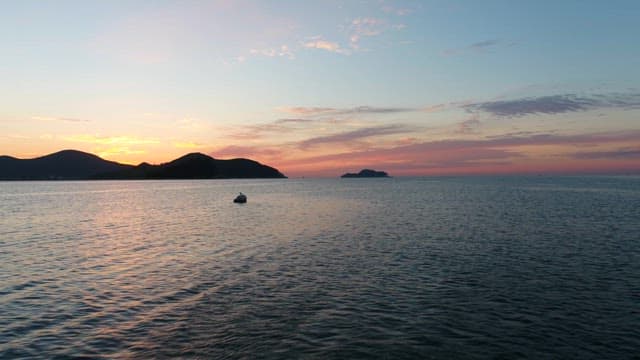 Calm Seascape at Dusk with Distant Islands and Seagulls