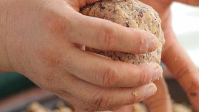 Hands shaping lump of soybean paste into a ball
