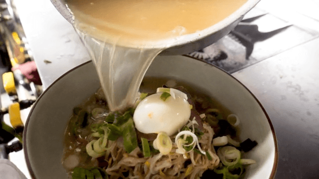 Warm broth poured over noodles topped with egg and beef