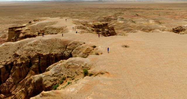 People exploring a vast desert landscape