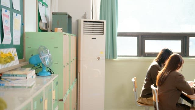 Student putting bag in locker and chatting with friends