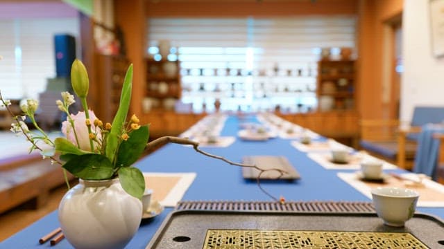 A beautifully set long table with tea settings in a traditionally decorated room