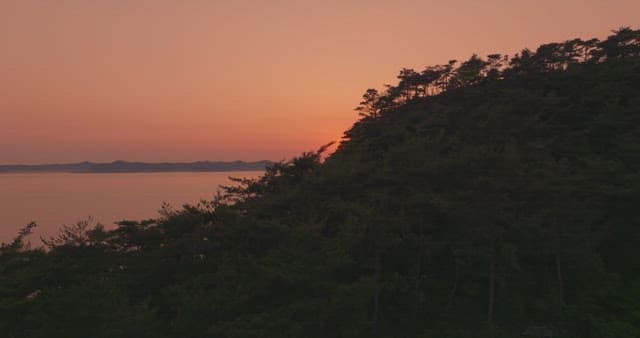Sunset over a calm sea with distant mountain