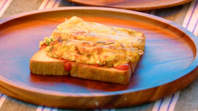 Preparing a simple toast with omelette, cheese and various sauces