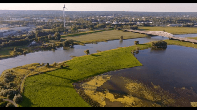 Scenic river with a bridge and wind turbine