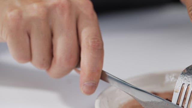 Person cutting juicy steak on a plate