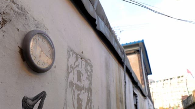 Wall clock on an urban alley wall