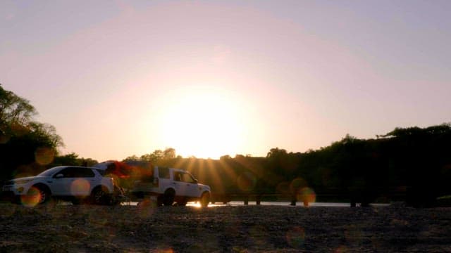 People enjoying camping by the river at sunset