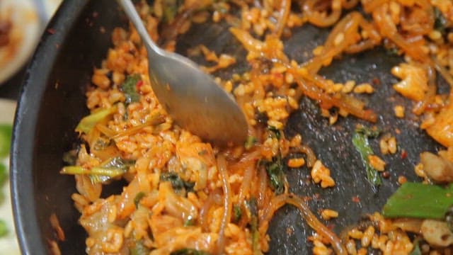 Appetizing fried rice being wrapped in sesame leaf