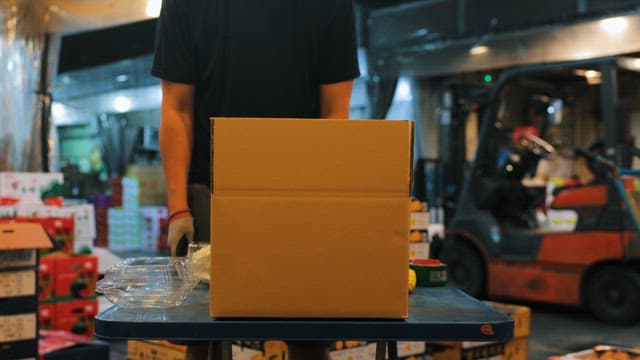 Person packing vegetables in a box