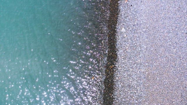 Sparkling water of the sea by pebble shore