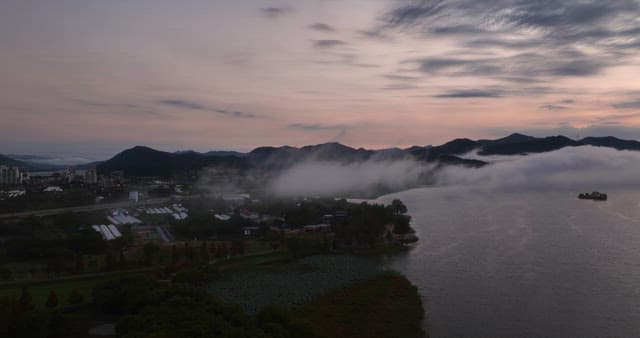 Serene river with misty mountains at dawn