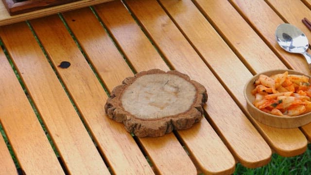 Outdoor picnic table setting with spicy ramen and kimchi