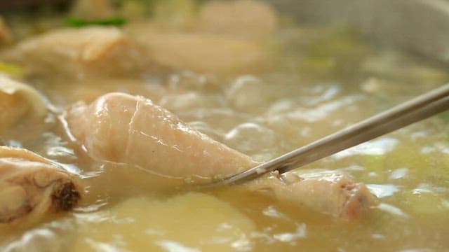 Picking up a piece of chicken using chopsticks